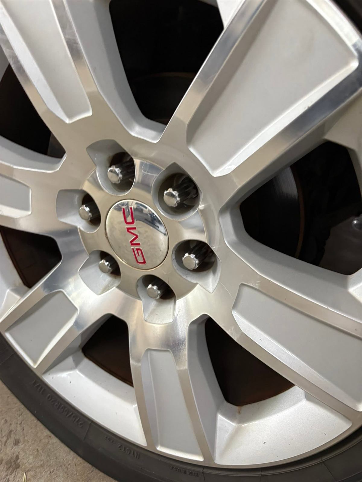 Polished GMC wheel with slotted rotor visible behind the spokes