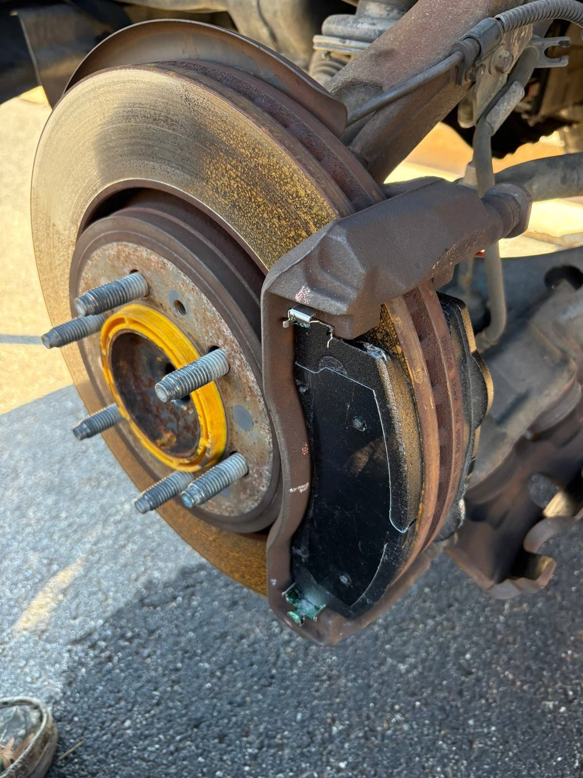 Worn shock absorber beside the new replacement unit